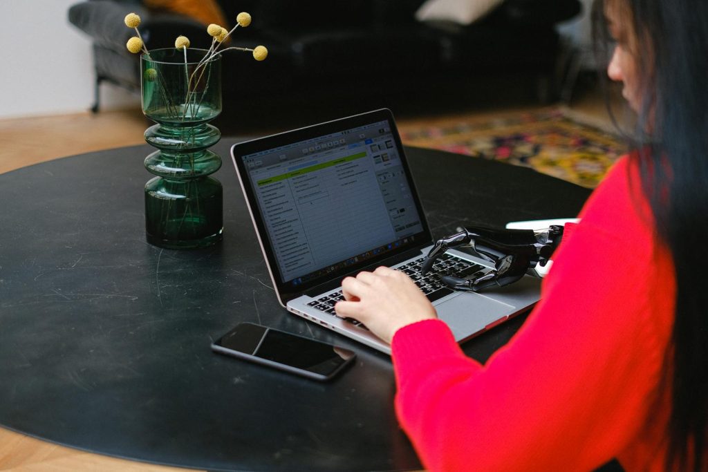 A Woman using Laptop with Prosthetic Hand